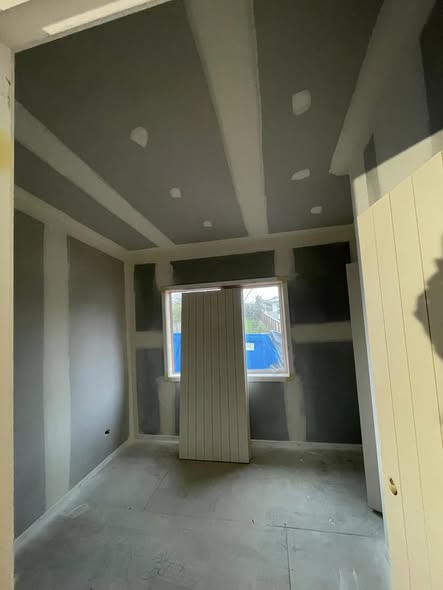 Interior of a new build, gib-stopped walls with paper tape detail, scaffold tower in centre of the room